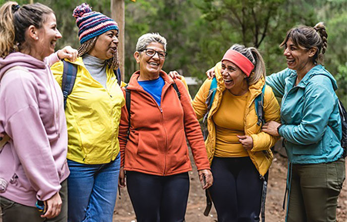 Five women laughing on a hiking trip.
