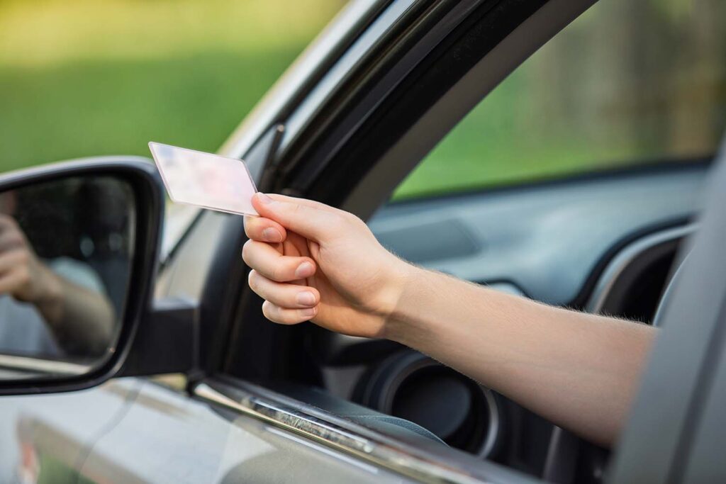 person holding their license out to a police officer