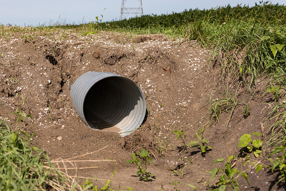 a culvert for drainage by a road.